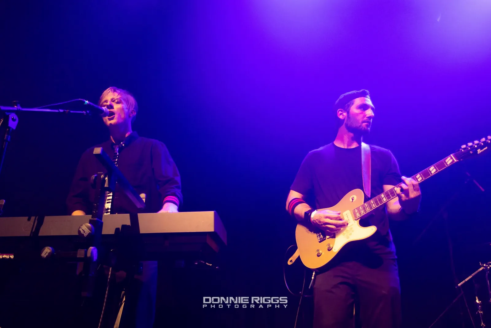 Jack playing electric guitar on stage under purple lights